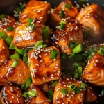 Golden seared honey garlic salmon bites in a skillet with sticky glaze