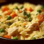A creamy Chicken Pot Pie Orzo served in a dish, showcasing its rich ingredients.