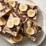 Frozen Peanut Butter Chocolate Greek Yogurt Bark topped with nuts and chocolate