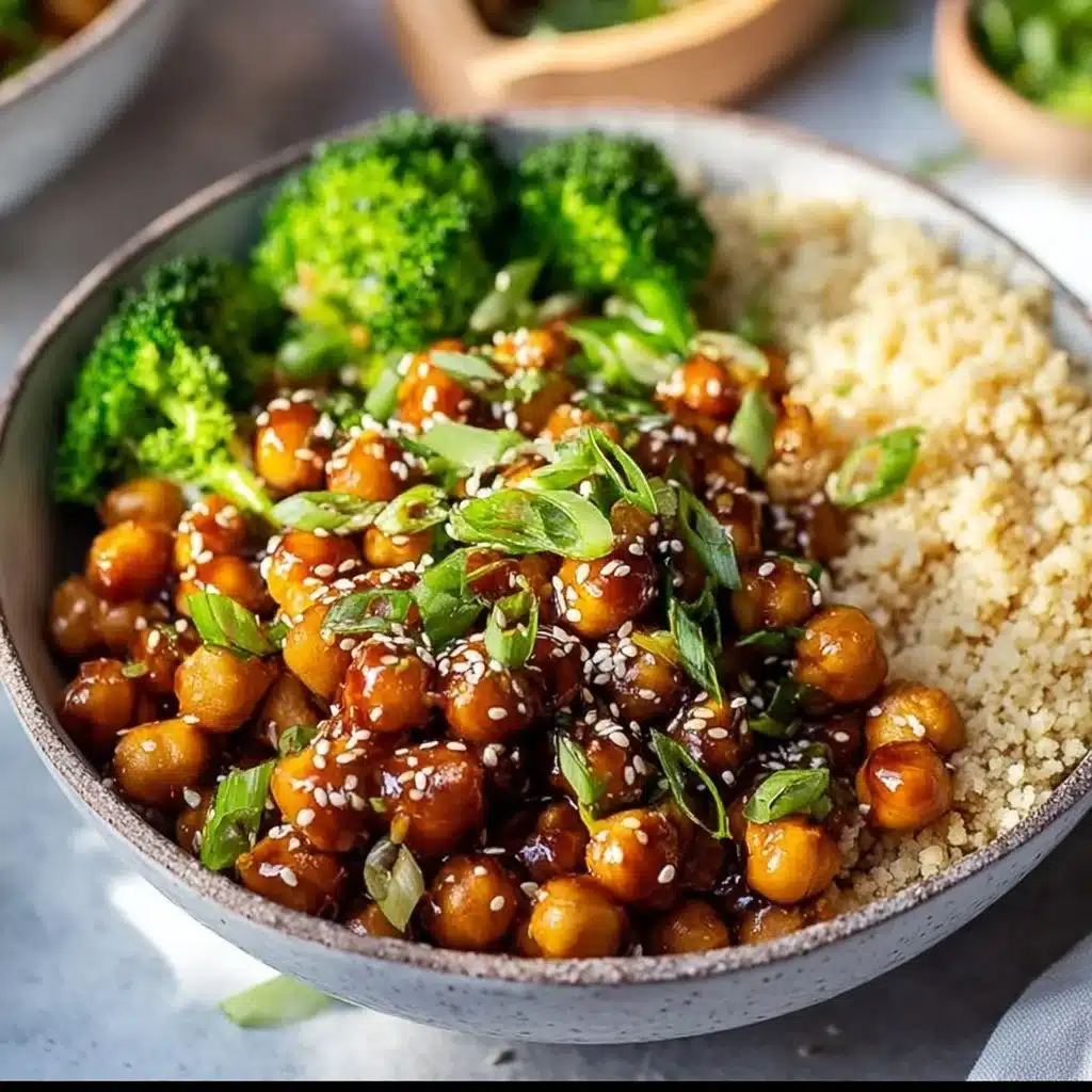 Sticky sesame chickpeas served in a bowl, garnished with sesame seeds and herbs.