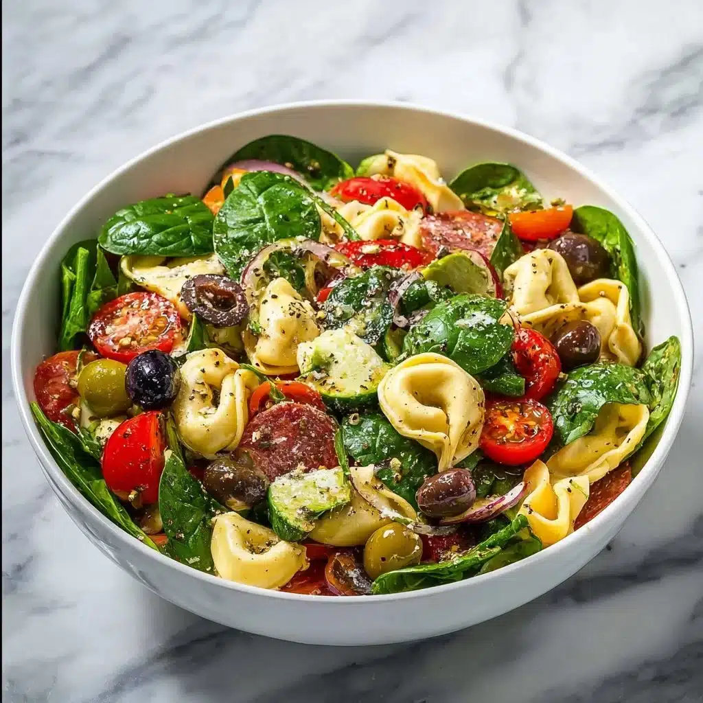 Bowl of colorful tortellini pasta salad with fresh vegetables and dressing
