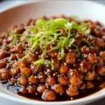 Vegan sticky sesame chickpeas served with fresh herbs and sesame seeds