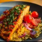 Lemon Orzo served with salmon, garnished with herbs and lemon slices.