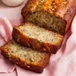 Loaf of freshly baked Banana Nut Bread with walnuts on a wooden table