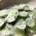 Freshly prepared cucumber salad with herbs and dressing in a bowl