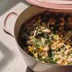 Freshly cooked orzo pasta garnished with herbs and vegetables