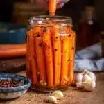 Jars of homemade Hot Honey Pickled Carrots on a kitchen counter
