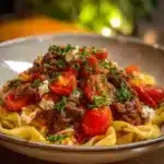 A bowl of Viral Turkish Pasta garnished with fresh herbs and spices.