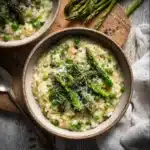 Delicious asparagus pea risotto served in a bowl, garnished with fresh herbs.