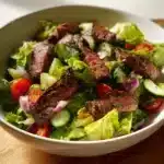 High-protein steak salad with fresh vegetables and dressing