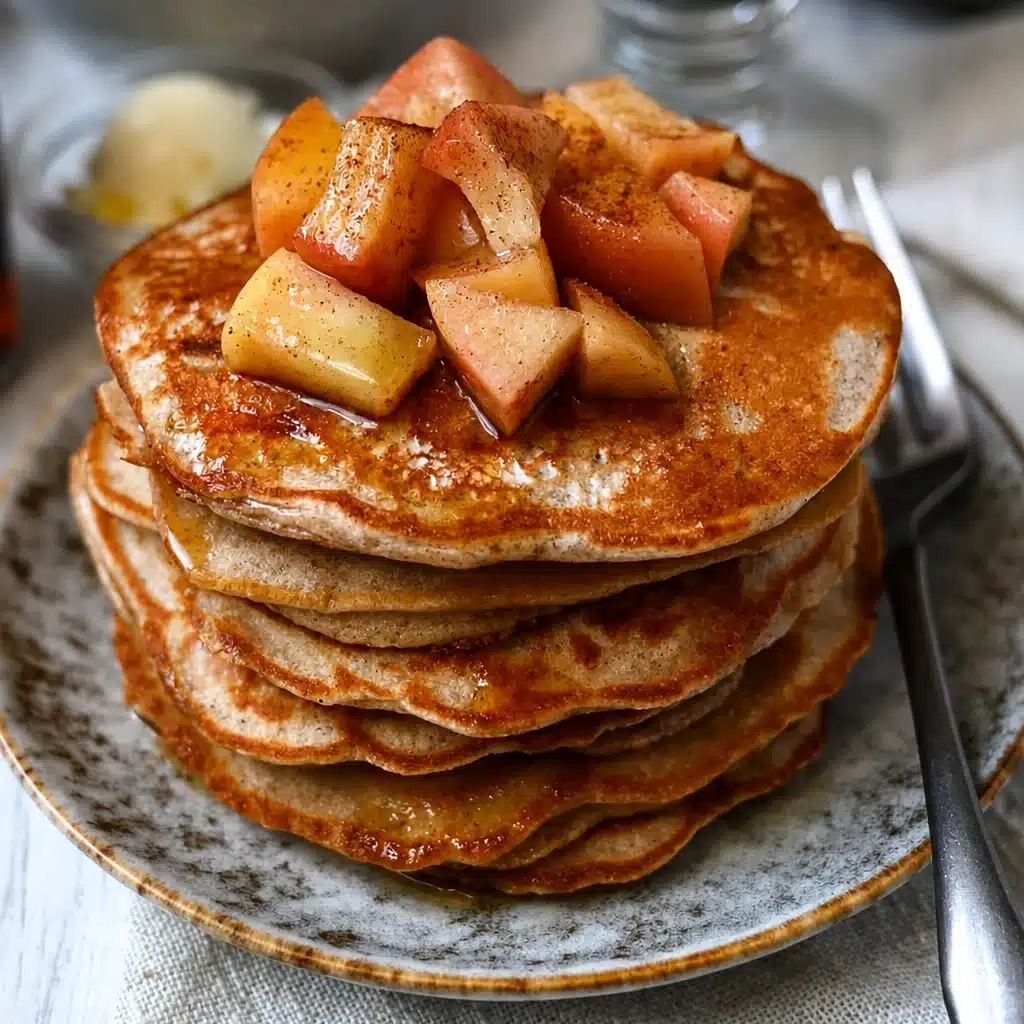 Macro-Friendly Apple Cinnamon Protein Pancakes topped with fresh apples and cinnamon.
