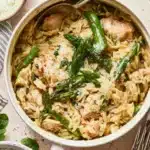 High protein chicken orzo dish served in a bowl, garnished with herbs