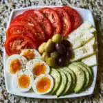 Colorful Mediterranean breakfast power plate with olives, feta, and vegetables.