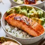 Baked salmon sushi bowl with fresh ingredients and sushi rice.